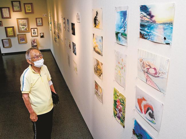作品を見る来場者＝出雲市多伎町小田、海辺の多伎図書館