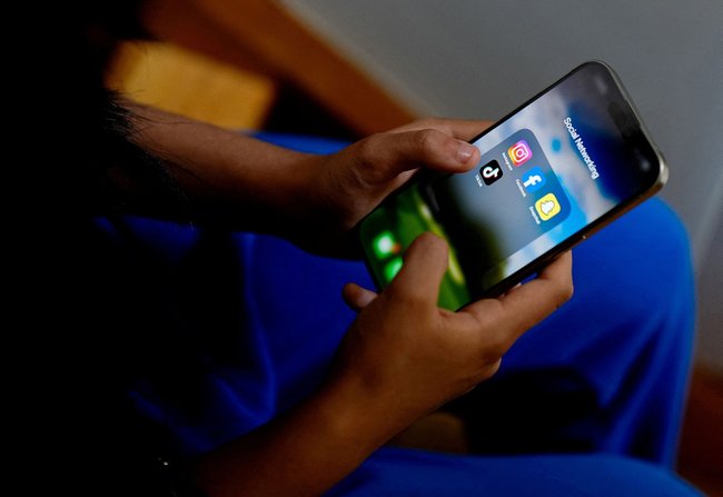 スマートフォンを使う高校生＝２０２４年１１月、オーストラリア・メルボルン（ロイター＝共同）