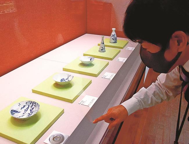船通山と斐伊川が描かれた杯を紹介する岡宏三専門学芸員＝出雲市大社町杵築東、島根県立古代出雲歴史博物館